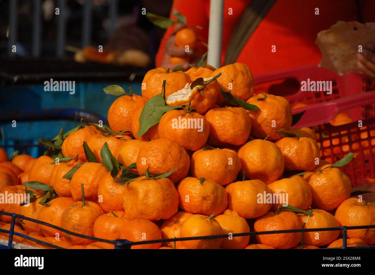 Una vivace bancarella di frutta in un mercato tailandese che espone un mucchio di arance fresche, mostrando i prodotti esotici della Thailandia sul mercato di strada in una giornata di sole Foto Stock
