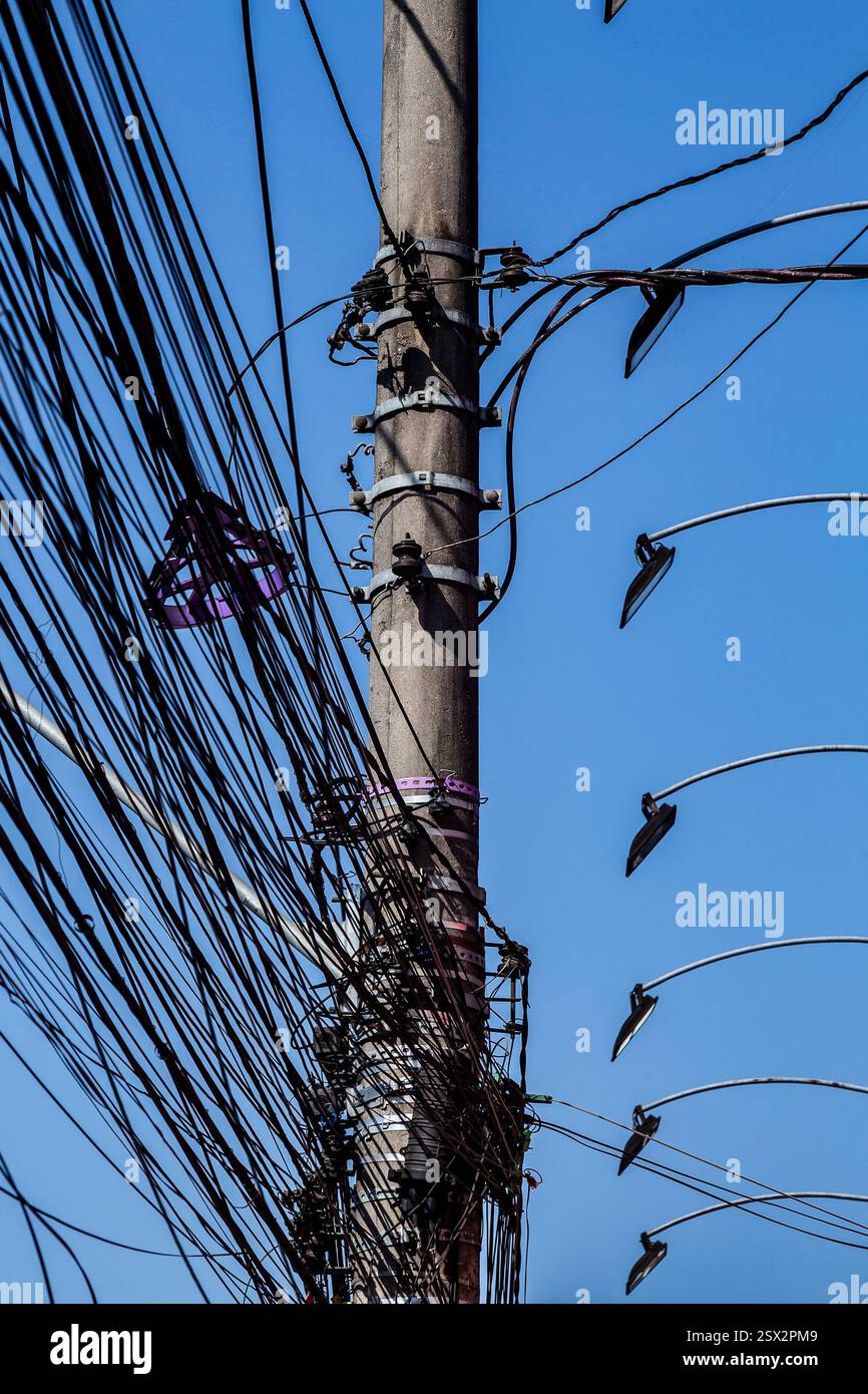 Cavi elettrici disordinati sul palo, il caos di cavi e fili su un palo elettrico nella città di San Paolo, Brasile Foto Stock