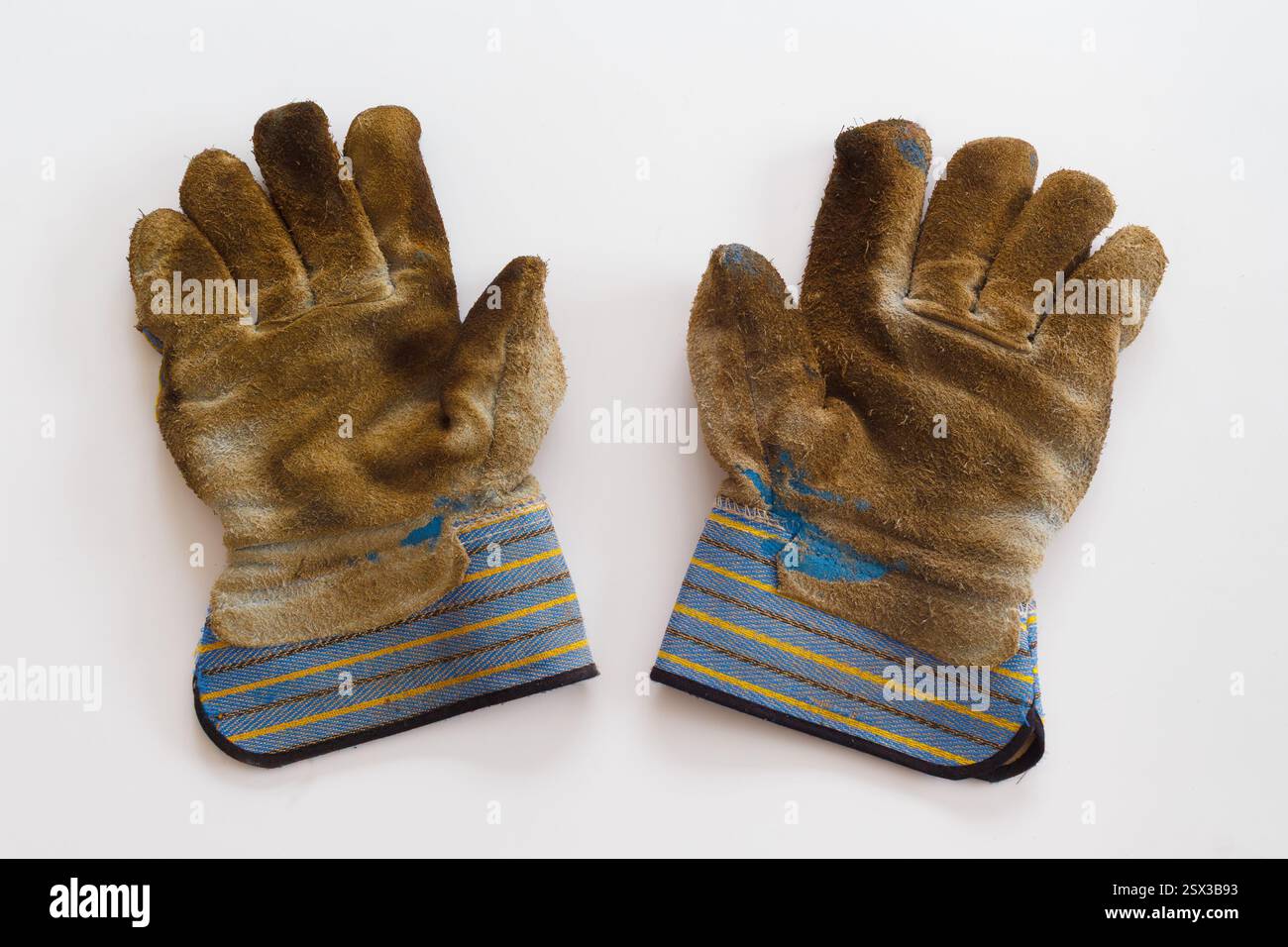 Un paio di guanti da lavoro ben usati Foto Stock
