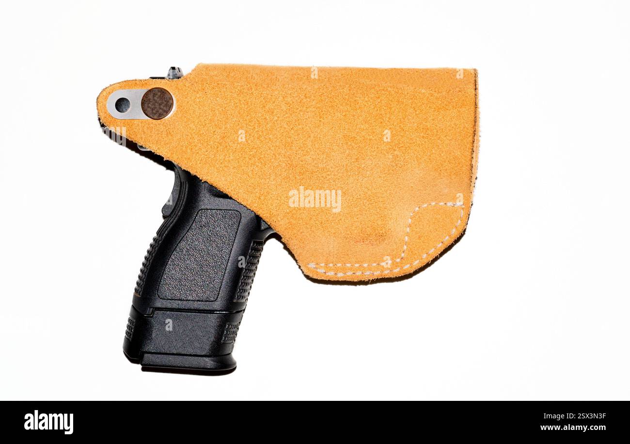Pistola semiautomatica nera con fondina in pelle sfondo bianco vista laterale. Foto Stock