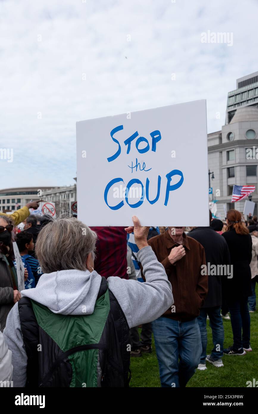 San Francisco, California, Stati Uniti, 17 febbraio 2025. Un manifestante tiene un cartello con la scritta "Stop the Coup" in occasione di una protesta contro il presidente Donald Trump e le azioni della squadra DOGE di Elon Musk durante una protesta del Presidents Day "No Kings" al municipio di San Francisco. Centinaia di manifestanti si sono rivelati per l'evento di base. Crediti: Shelly Rivoli/Alamy Foto Stock