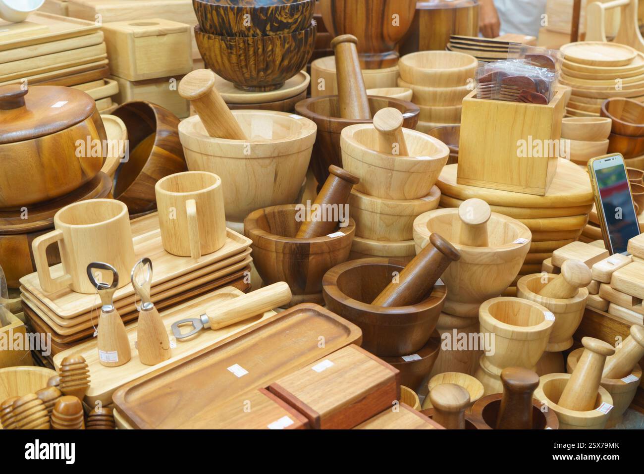 foto ravvicinata di una varietà di utensili in legno artigianali, tra cui cucchiai, spatole e mestoli, esposti in una bancarella del mercato. Foto Stock