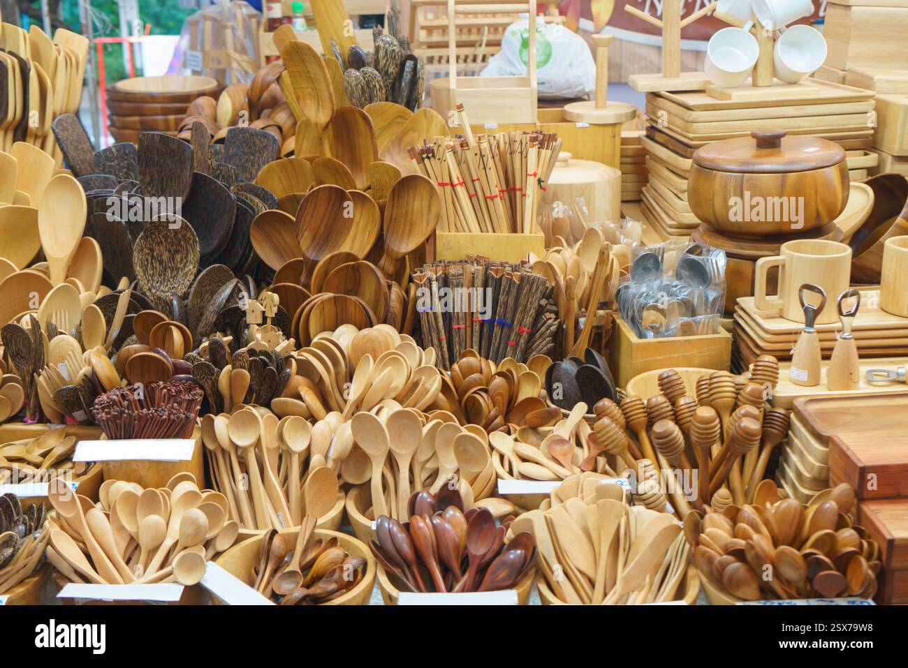 foto ravvicinata di una varietà di utensili in legno artigianali, tra cui cucchiai, spatole e mestoli, esposti in una bancarella del mercato. Foto Stock