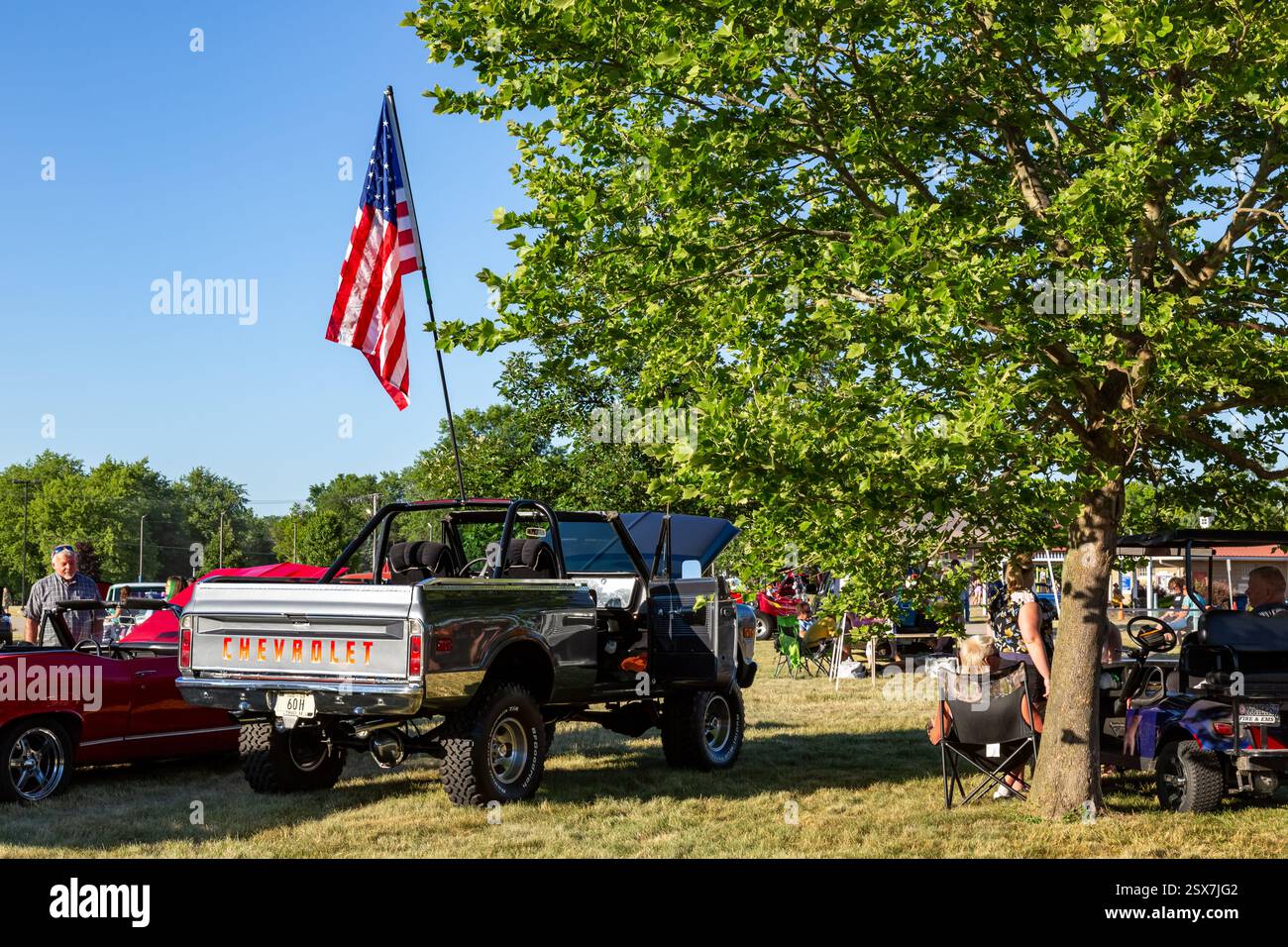 Una bandiera degli Stati Uniti è issata sopra una Chevrolet Blazer grigia del 1969 in mostra in una mostra di auto al Riverside Gardens Park di Leo-Cedarville, Indiana, USA. Foto Stock