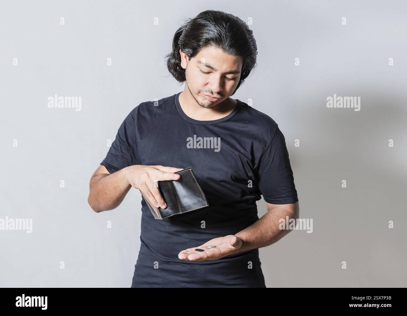 Uomo infelice con crisi finanziaria isolata. Persona con portafoglio di gestione per crisi finanziarie. Uomo triste che tiene isolato un portafoglio vuoto Foto Stock