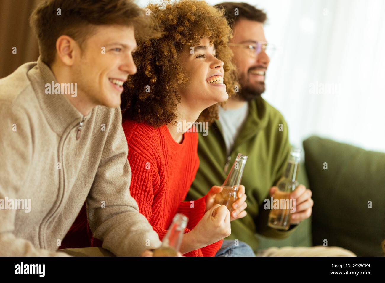Tre amici si siedono insieme, mentre trascorrono felicemente i momenti della vita. La risata riempie la stanza, evidenziando il calore dell'amicizia ov Foto Stock