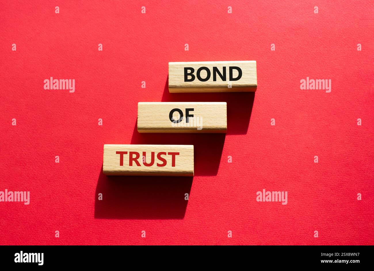 Simbolo del legame di fiducia. Blocchi di legno con parole Bond of Trust. Bellissimo sfondo rosso. Business e Bond of Trust. Copia spazio. Foto Stock