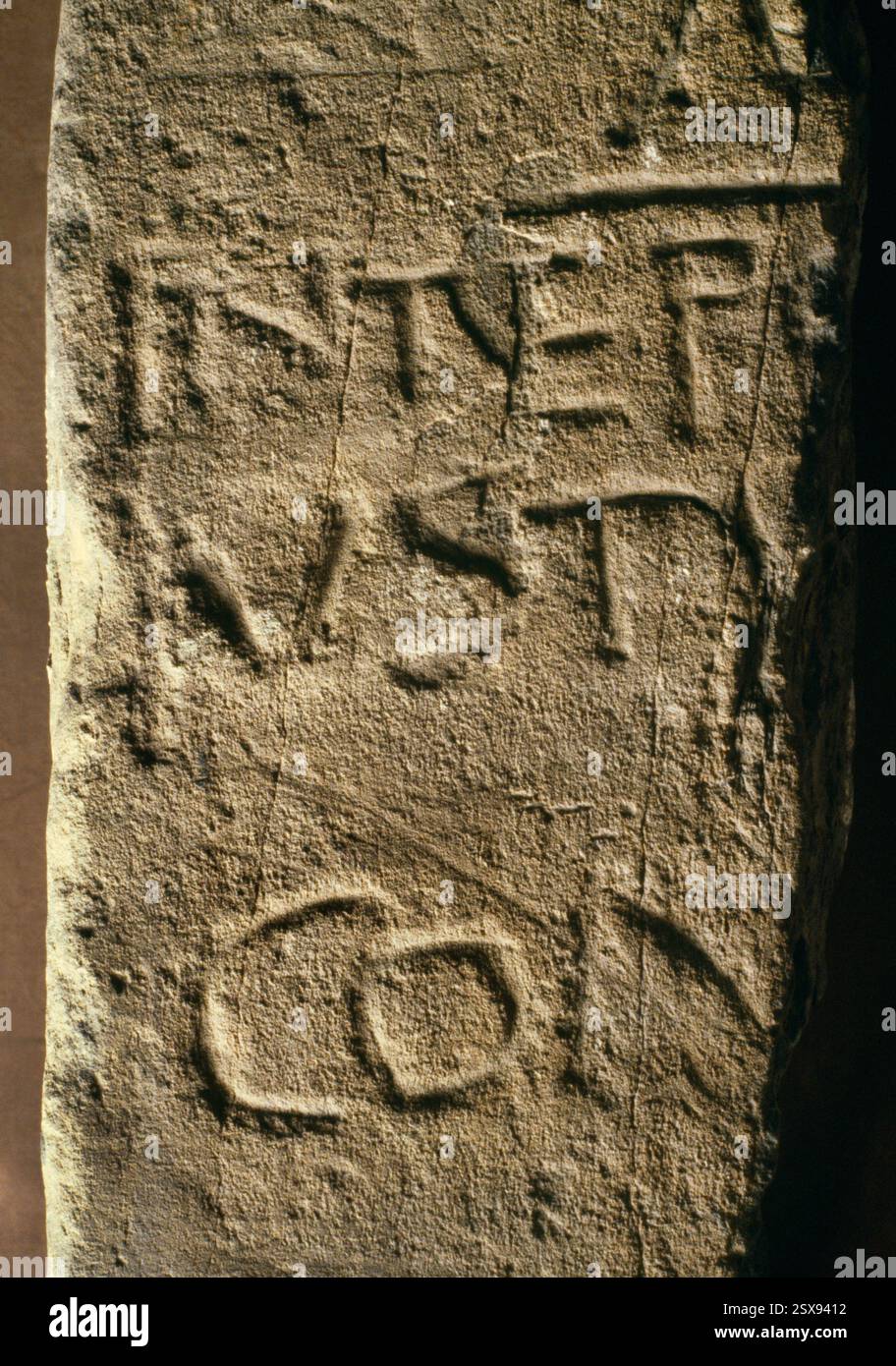 Particolare dell'iscrizione orizzontale inferiore sulla pietra degli Avitori (Avitorius), un memoriale della metà del sesto secolo conservato nella chiesa parrocchiale di Penmachno, Conwy, Galles, Regno Unito. Foto Stock