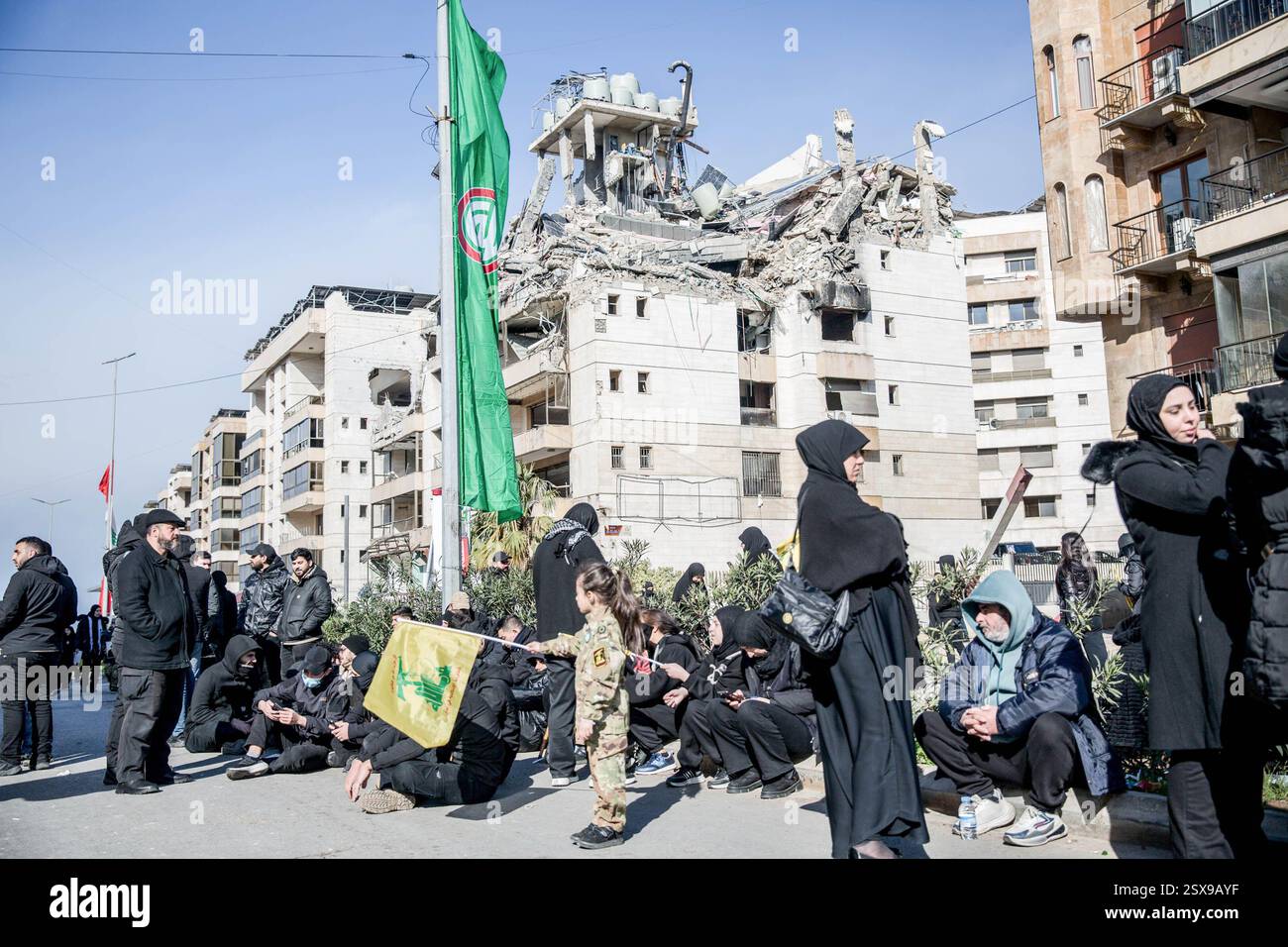Beirut, Libano. 23 febbraio 2025. I lutti aspettano di fronte a un sito di attacco aereo nella periferia meridionale di Beirut, prima della cerimonia funebre di Hassan Nasrallah. Il segretario generale di Hezbollah Hassan Nasrallah è stato ucciso il 27 settembre 2024, quando Israele ha sganciato decine di bombe "bunker buster" sulla sua posizione nella periferia meridionale di Beirut. Credito: SOPA Images Limited/Alamy Live News Foto Stock