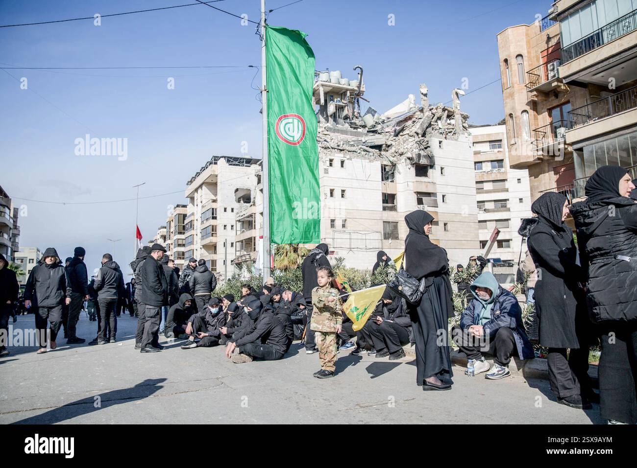 Beirut, Libano. 23 febbraio 2025. I lutti aspettano di fronte a un sito di attacco aereo nella periferia meridionale di Beirut, prima della cerimonia funebre di Hassan Nasrallah. Il segretario generale di Hezbollah Hassan Nasrallah è stato ucciso il 27 settembre 2024, quando Israele ha sganciato decine di bombe "bunker buster" sulla sua posizione nella periferia meridionale di Beirut. Credito: SOPA Images Limited/Alamy Live News Foto Stock