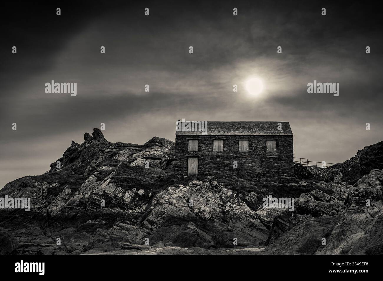 Sun Over Peak Rock & the Net Loft edificio classificato di grado 2, Polperro, Cornwal, Regno Unito Foto Stock