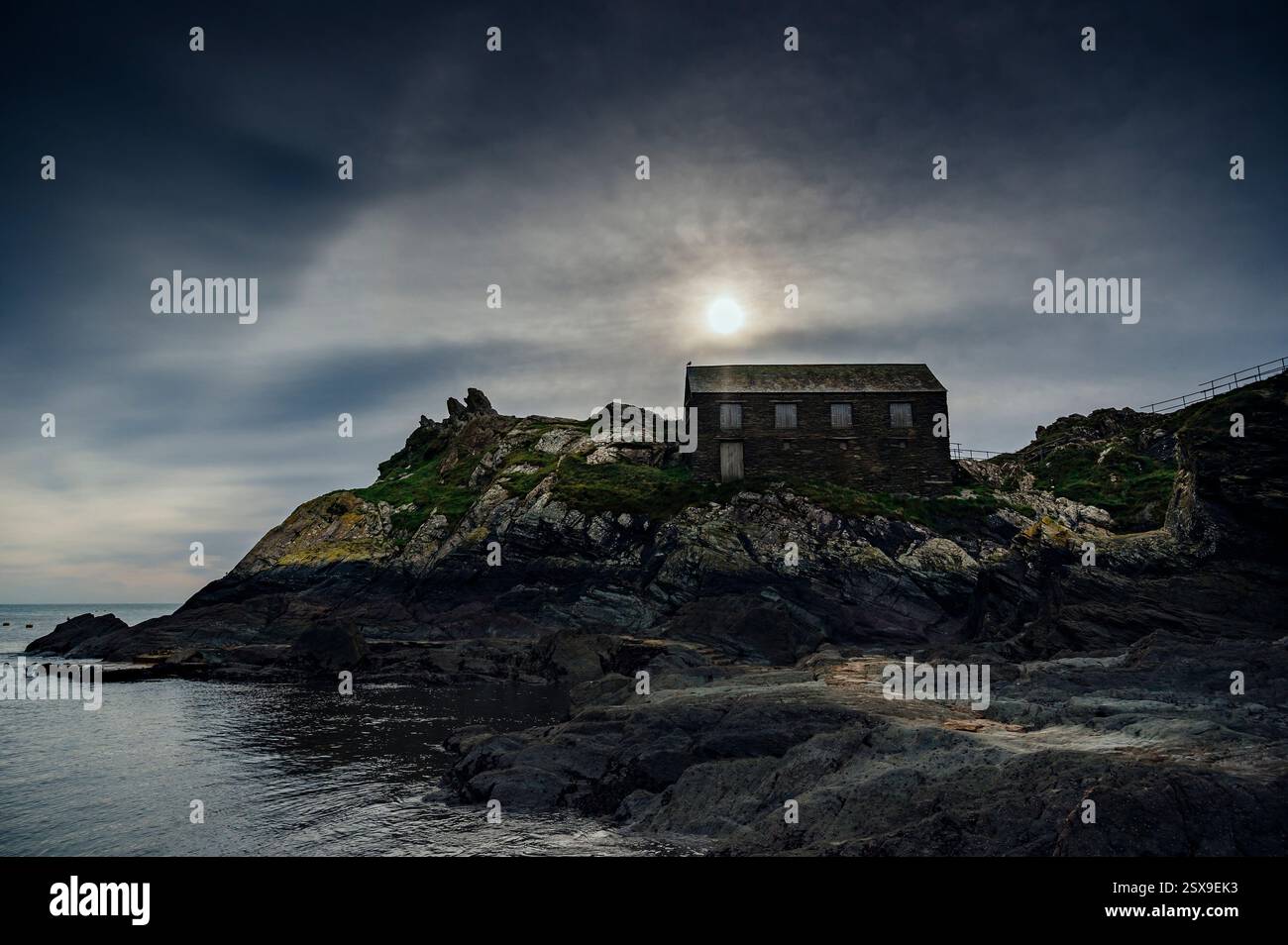 Sun Over Peak Rock & the Net Loft edificio classificato di grado 2, Polperro, Cornwal, Regno Unito Foto Stock