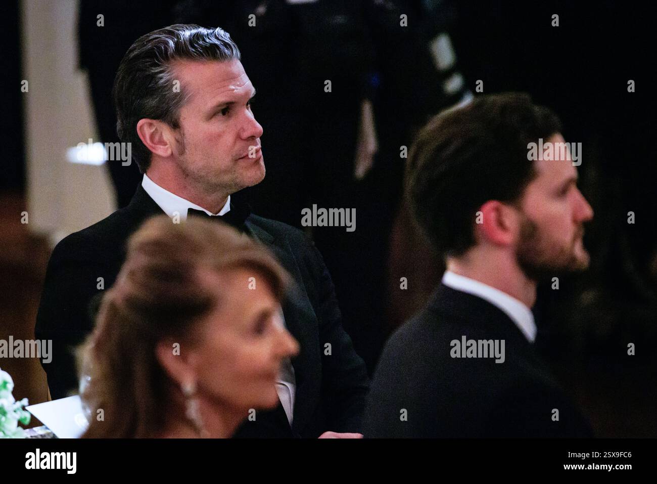 Il Segretario alla difesa degli Stati Uniti Pete Hegseth ascolta il presidente degli Stati Uniti Donald J Trump durante la cena della National Governors Association (NGA) nella East Room della Casa Bianca a Washington, DC il 22 febbraio 2025.credito: Samuel Corum/Pool via CNP /MediaPunch Foto Stock