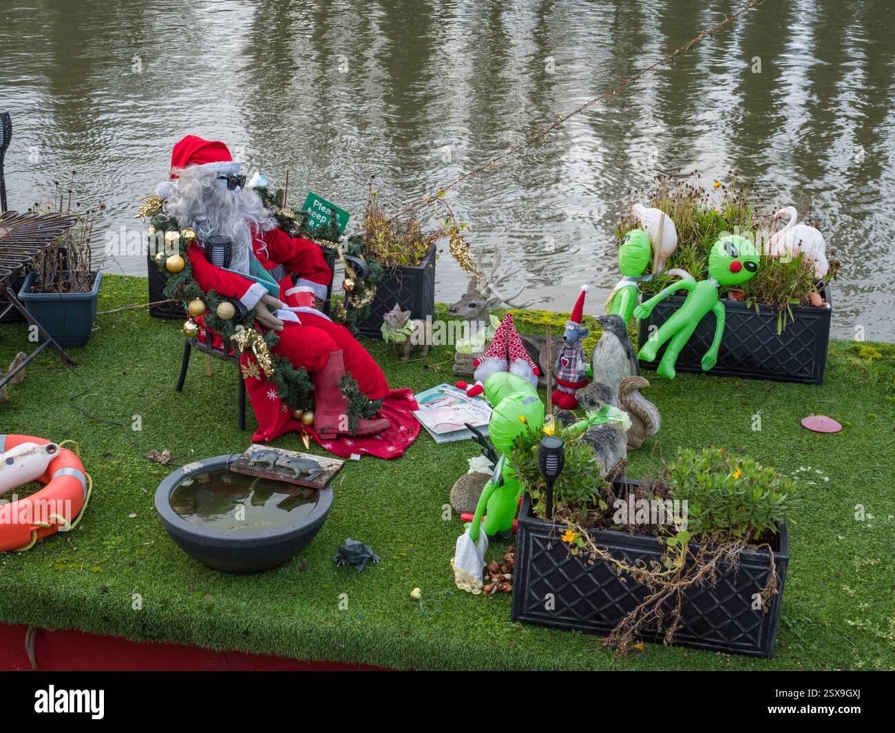 Babbo Natale e ornamenti alieni su una casa galleggiante sul fiume Tamigi a Surbiton, Londra, Regno Unito. Foto Stock