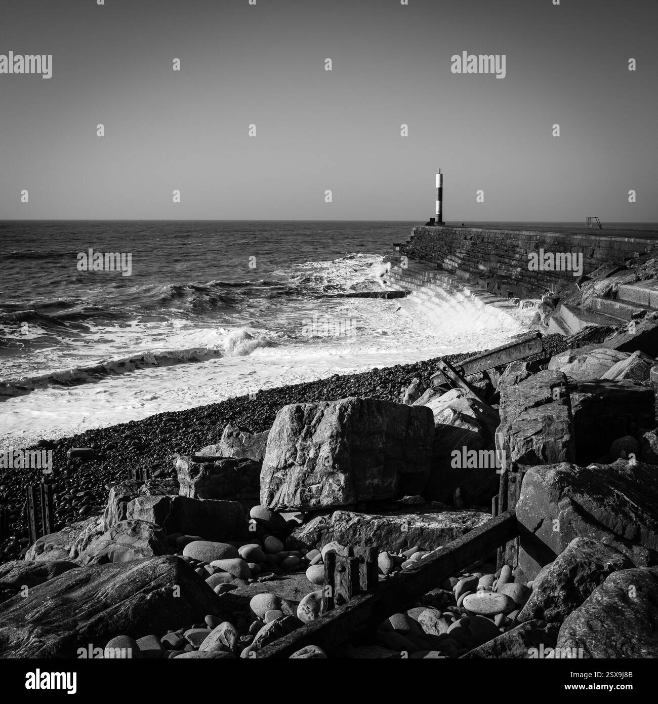 Onde che si infrangono sul frangiflutti di Aberystwyth Foto Stock