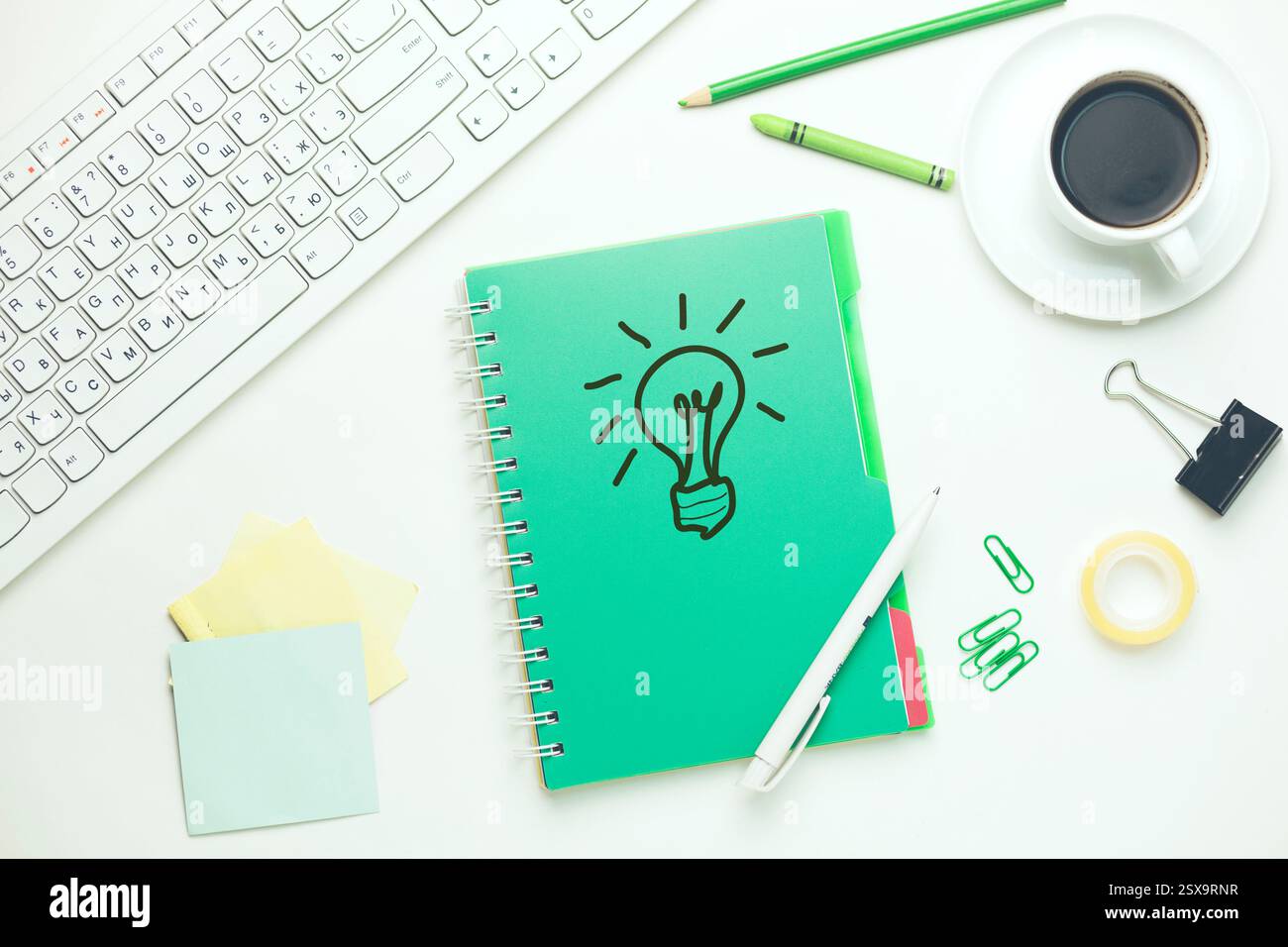 lampadina su notebook con tastiera e fisso sul tavolo Foto Stock