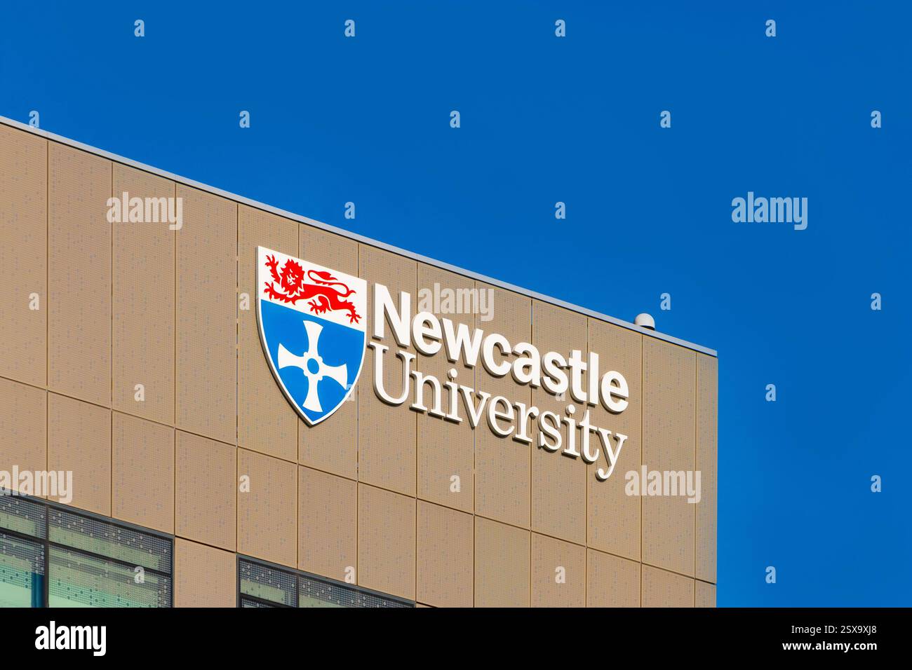 Moderna vista esterna dell'edificio delle scienze urbane della Newcastle University con il suo logo di spicco su un cielo azzurro Foto Stock