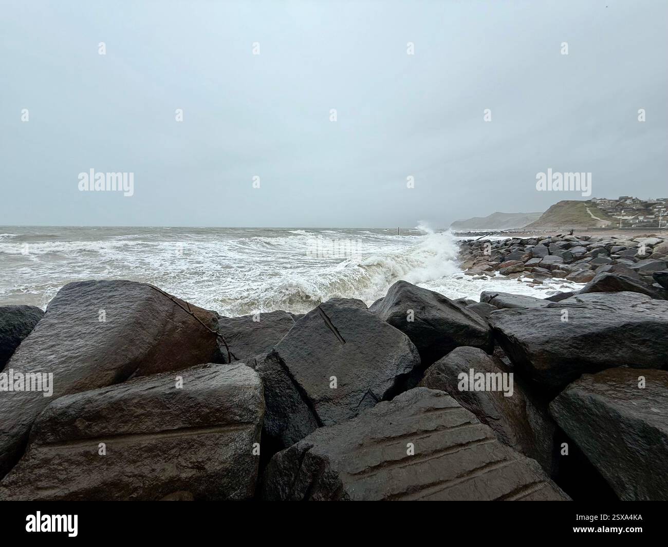 West Bay, Dorset: Le difese marine e il Mare Rough - Immagine stock catturata con smartphone