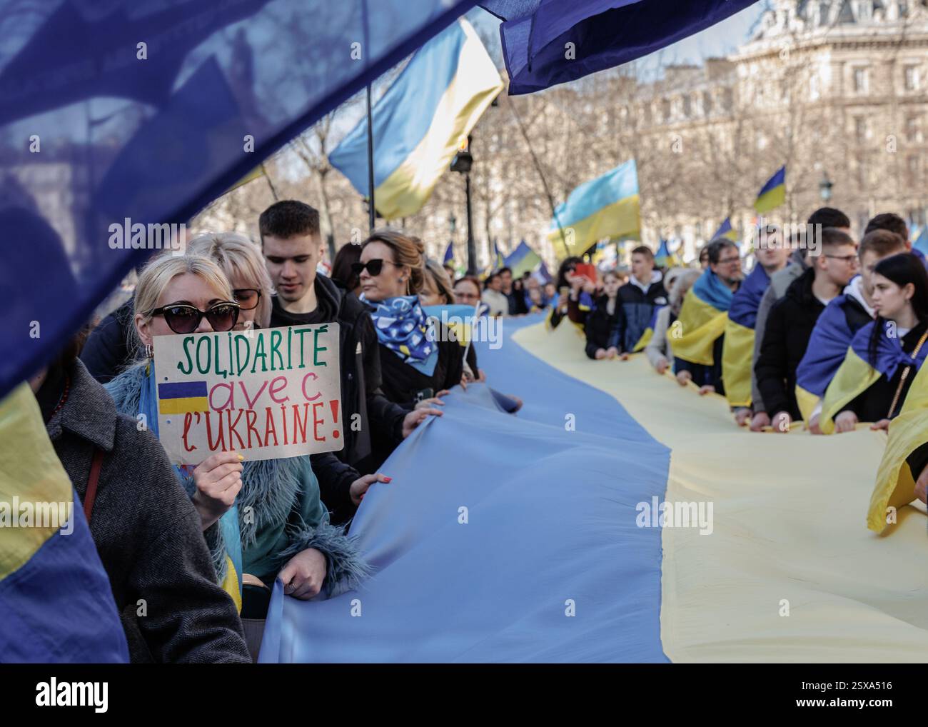 Saint Ouen, Parigi, Francia. 23 febbraio 2025. I manifestanti marciano con cartelli e bandiere ucraine durante una manifestazione a sostegno dell'Ucraina alla vigilia del terzo anniversario dell'invasione russa del paese, a Parigi il 23 febbraio 2025. (Credit Image: © Sadak Souici/ZUMA Press Wire) SOLO PER USO EDITORIALE! Non per USO commerciale! Crediti: ZUMA Press, Inc./Alamy Live News Foto Stock