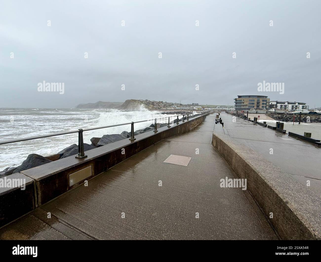 Guardando verso West Bay, Dorset dal molo di Harbour in un giorno di tempesta - Immagine stock catturata con smartphone