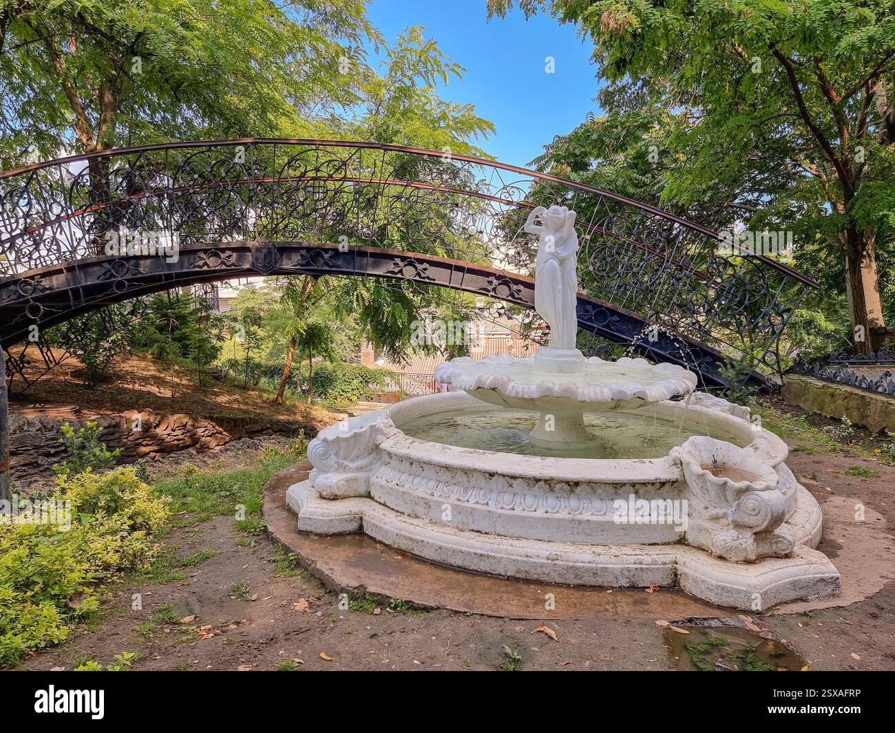 Piccola passerella in metallo e fontana con scultura nell'angolo della Vecchia Odesa / Odessa, un piccolo museo all'aperto vicino al Ponte Tioschin - Immagine stock catturata con smartphone