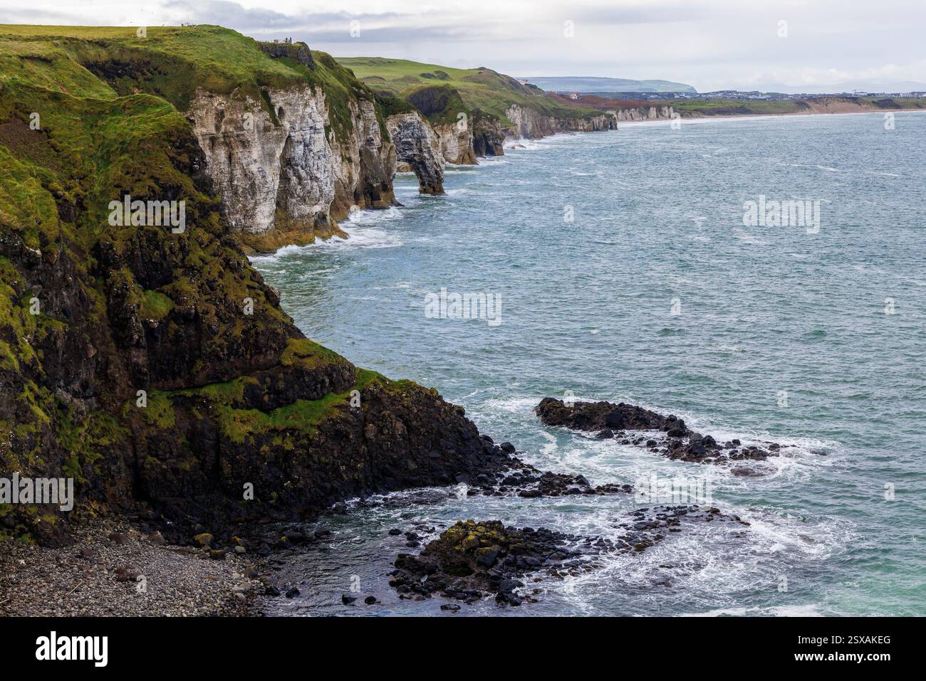 Scogliere costiere al castello di Dunluce, Bushmills, Co Antrim, Irlanda Foto Stock