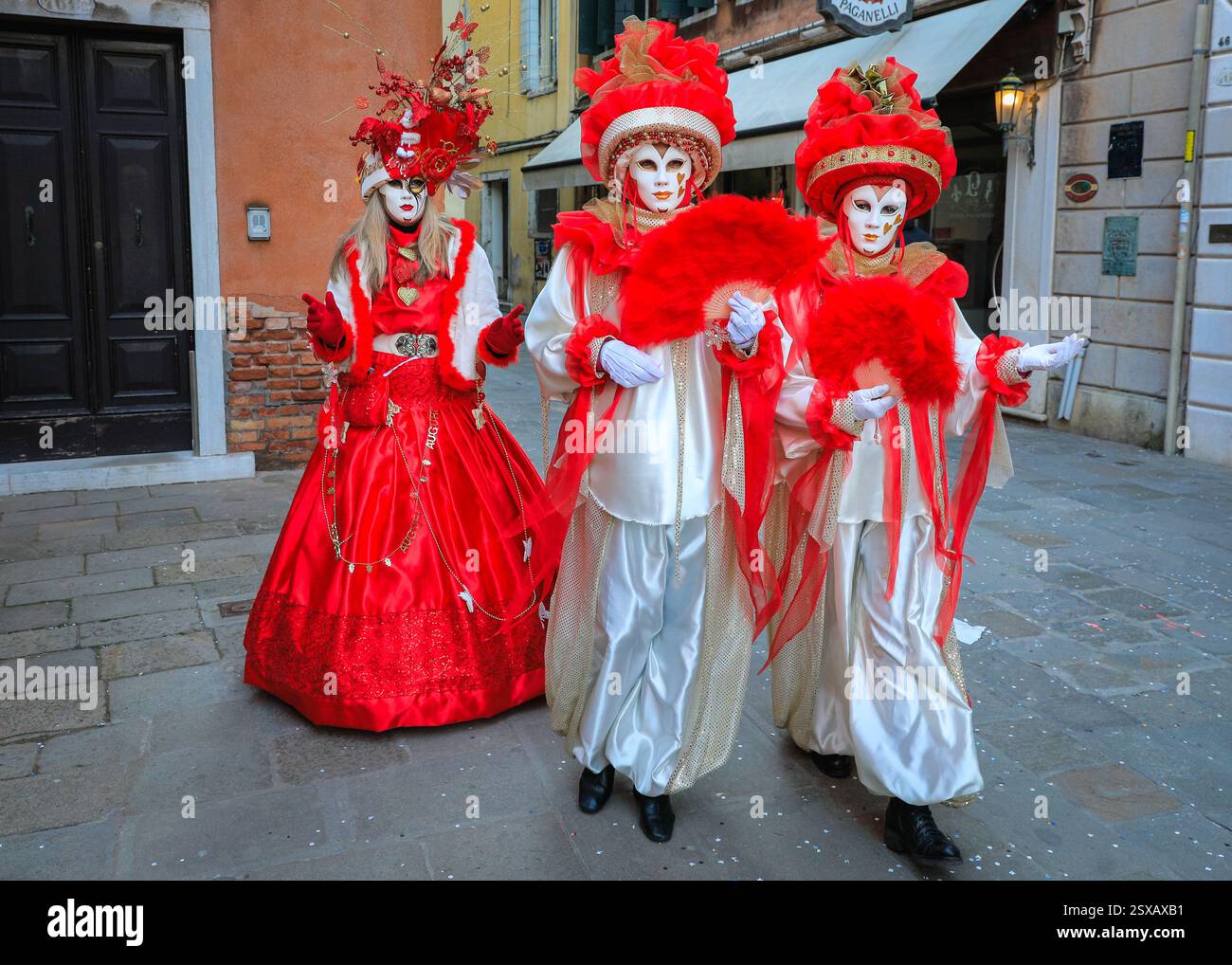 Il carnevale di Venezia, i partecipanti in costume in colorati costumi storici veneziani camminano lungo una strada, Venezia, Italia Foto Stock