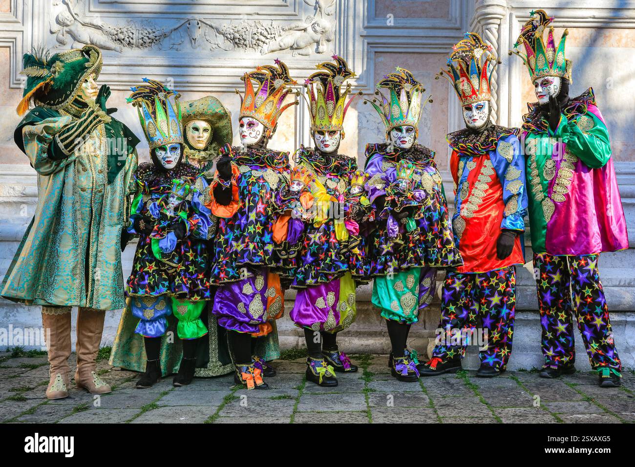 Carnevale di Venezia, un gruppo di festeggiatori e partecipanti ai colorati abiti di arlecchino posa, Venezia, Italia Foto Stock