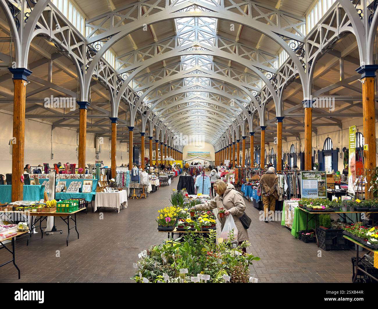 Barnstable, Devon, Inghilterra, Regno Unito - 21 febbraio 2025: Persone che curiosano tra le bancarelle nello storico mercato coperto Pannier nel centro della città di Barnstable. - Immagine stock catturata con smartphone