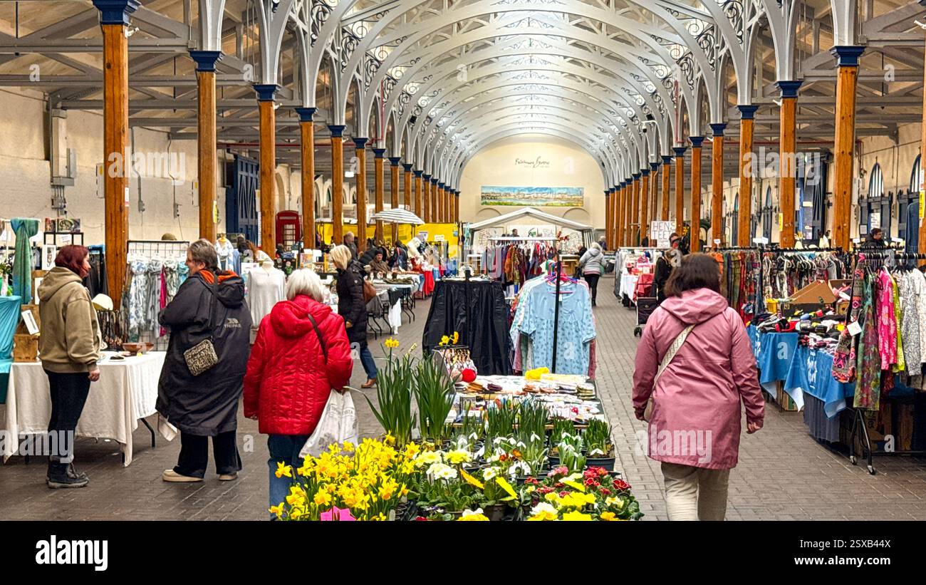 Barnstable, Devon, Inghilterra, Regno Unito - 21 febbraio 2025: Persone che curiosano tra le bancarelle nello storico mercato coperto Pannier nel centro della città di Barnstable. - Immagine stock catturata con smartphone
