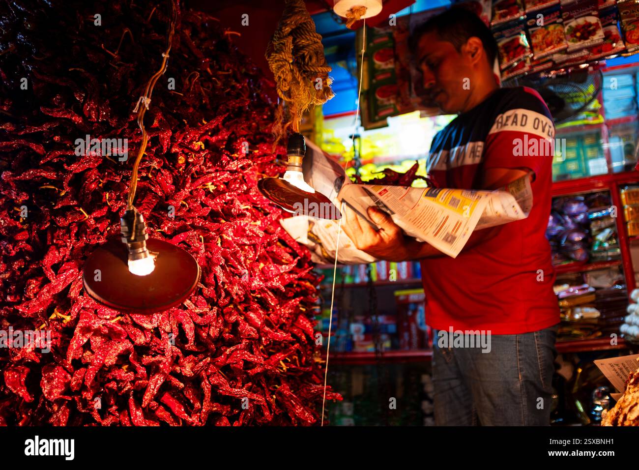 Un commerciante di mercato che vende peperoncini Kashmiri e altre spezie nel mercato interno, Margao, Goa, India Foto Stock