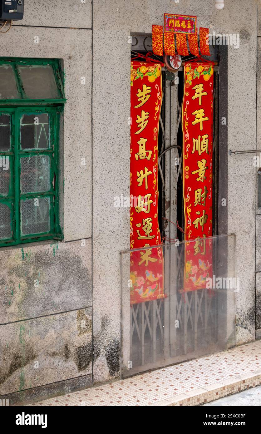Hong Kong. Cina- 02.13.2025. I giunti di primavera cinesi sono appesi alla porta di una casa del villaggio. Foto Stock