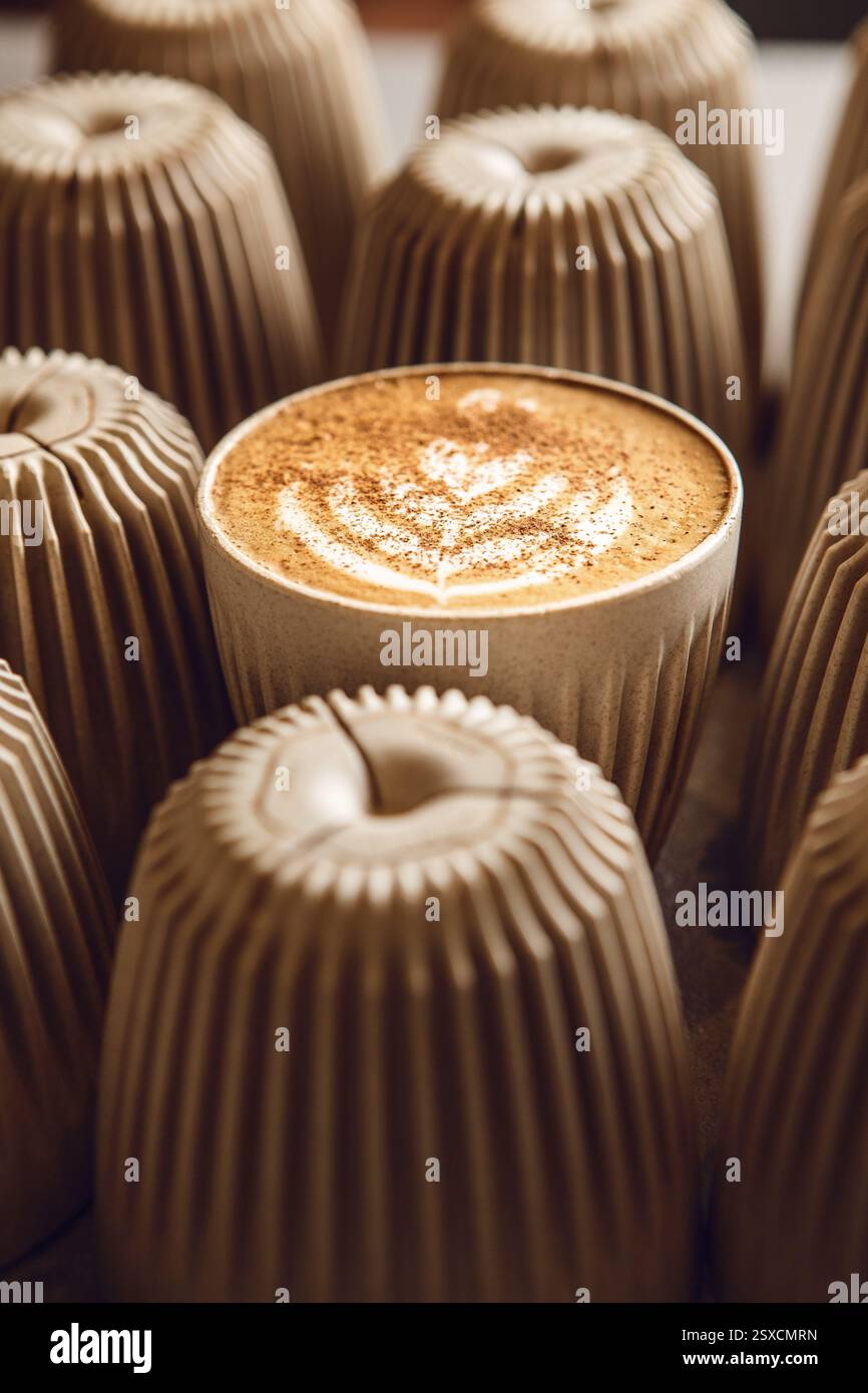 Cappuccino appena fatto con latte Art e cannella, in attesa di essere servito Foto Stock