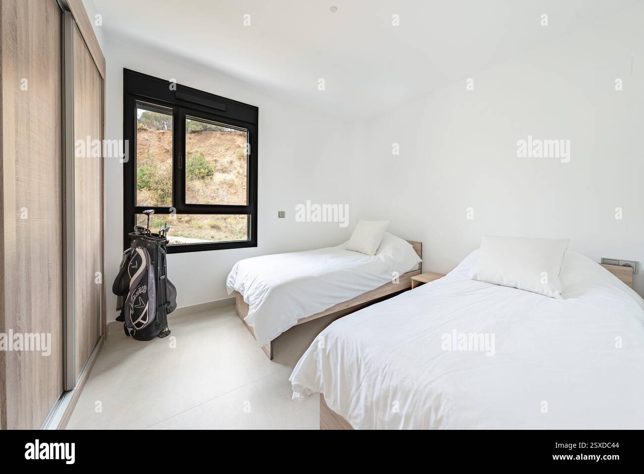un'immagine di due letti singoli con una serie di mazze da golf nella casa vacanze mediterranea Foto Stock