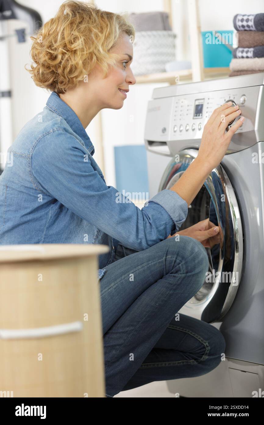 donna che ripara il ciclo di lavaggio Foto Stock