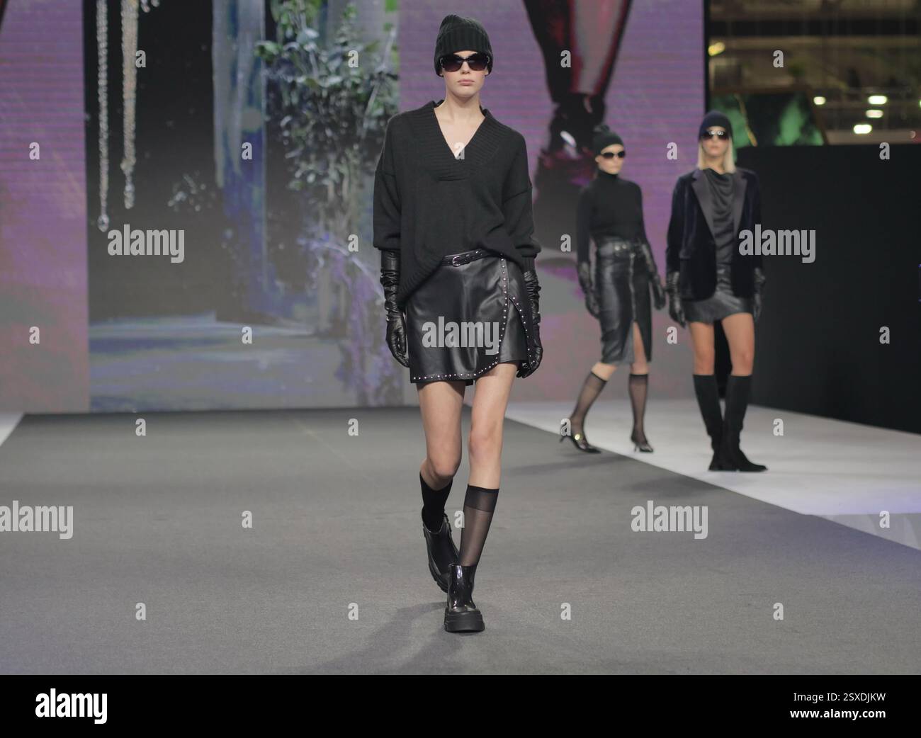 Sfilata Micam: Evento sfilata di moda, con nuove tendenze stilistiche delle calzature abbinate a ginocchiere in nylon nero. Foto Stock