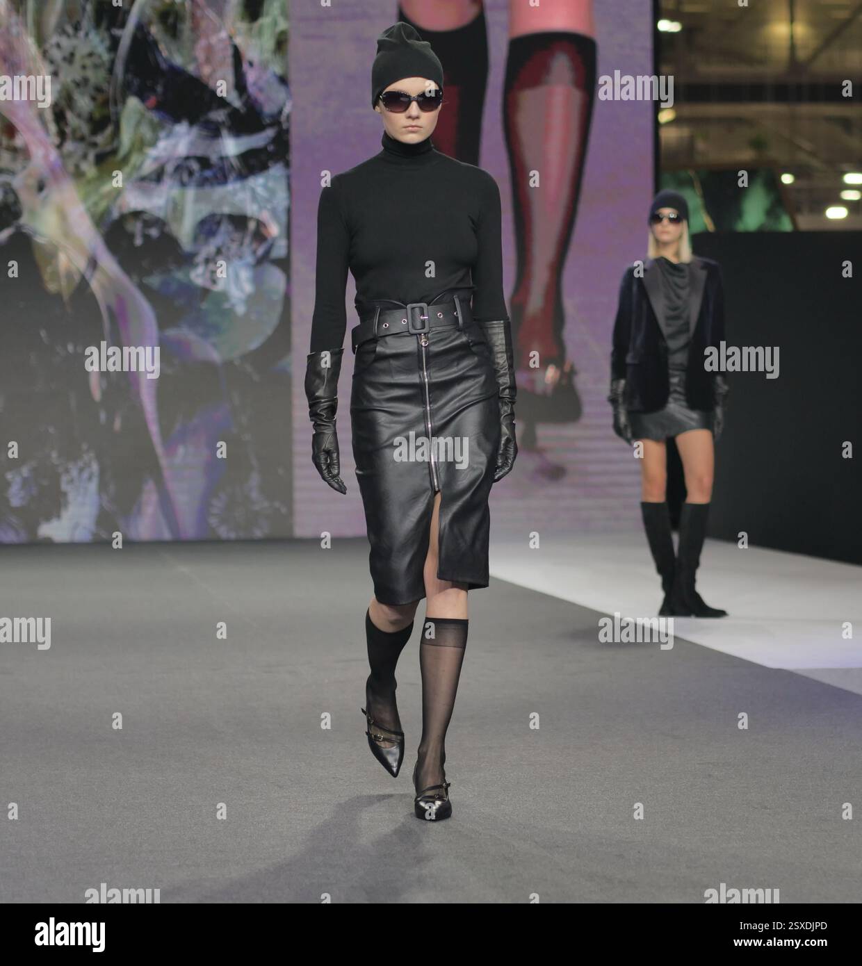 Sfilata Micam: Evento sfilata di moda, con nuove tendenze stilistiche delle calzature abbinate a ginocchiere in nylon nero. Foto Stock