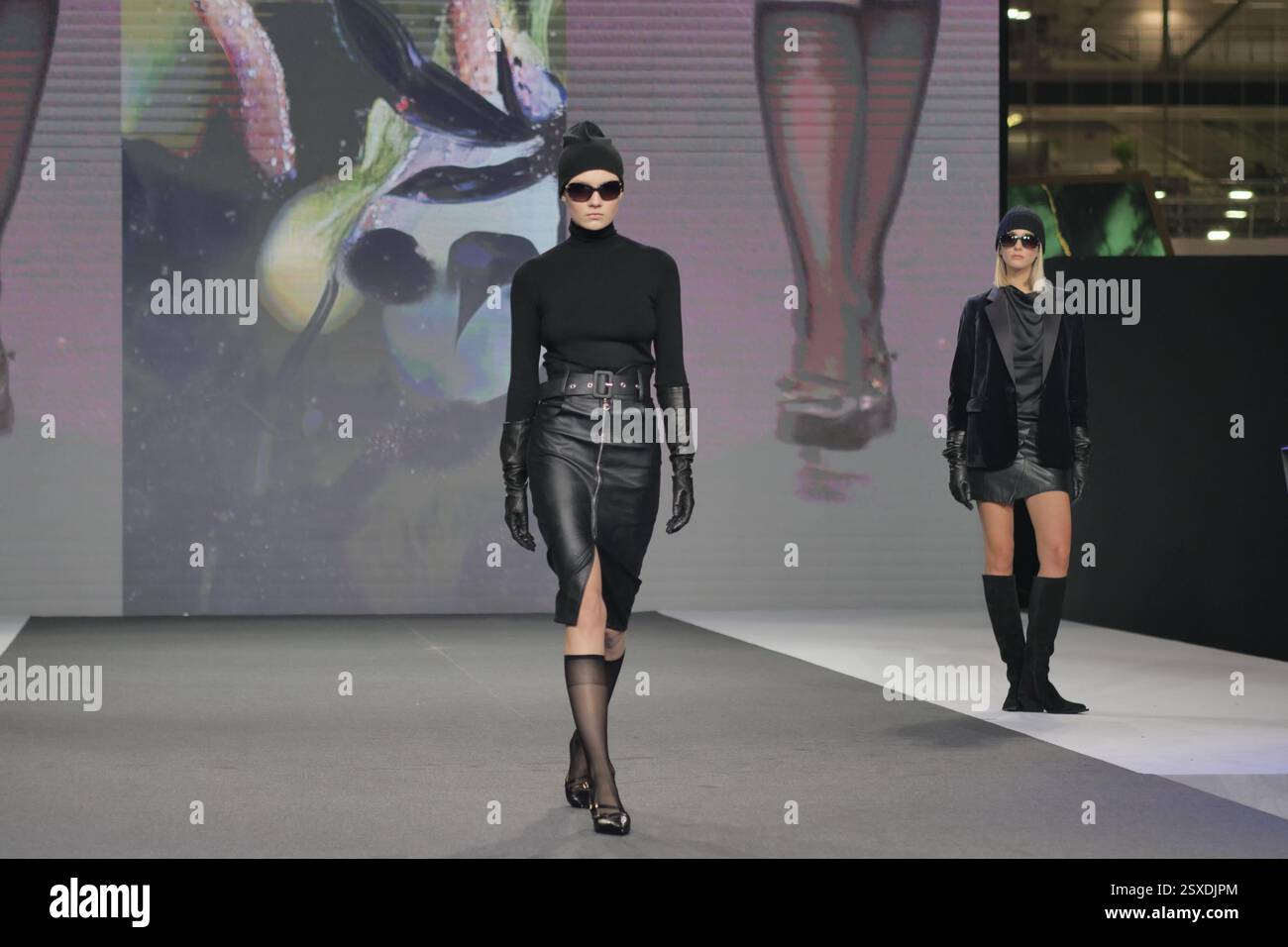 Sfilata Micam: Evento sfilata di moda, con nuove tendenze stilistiche delle calzature abbinate a ginocchiere in nylon nero. Foto Stock