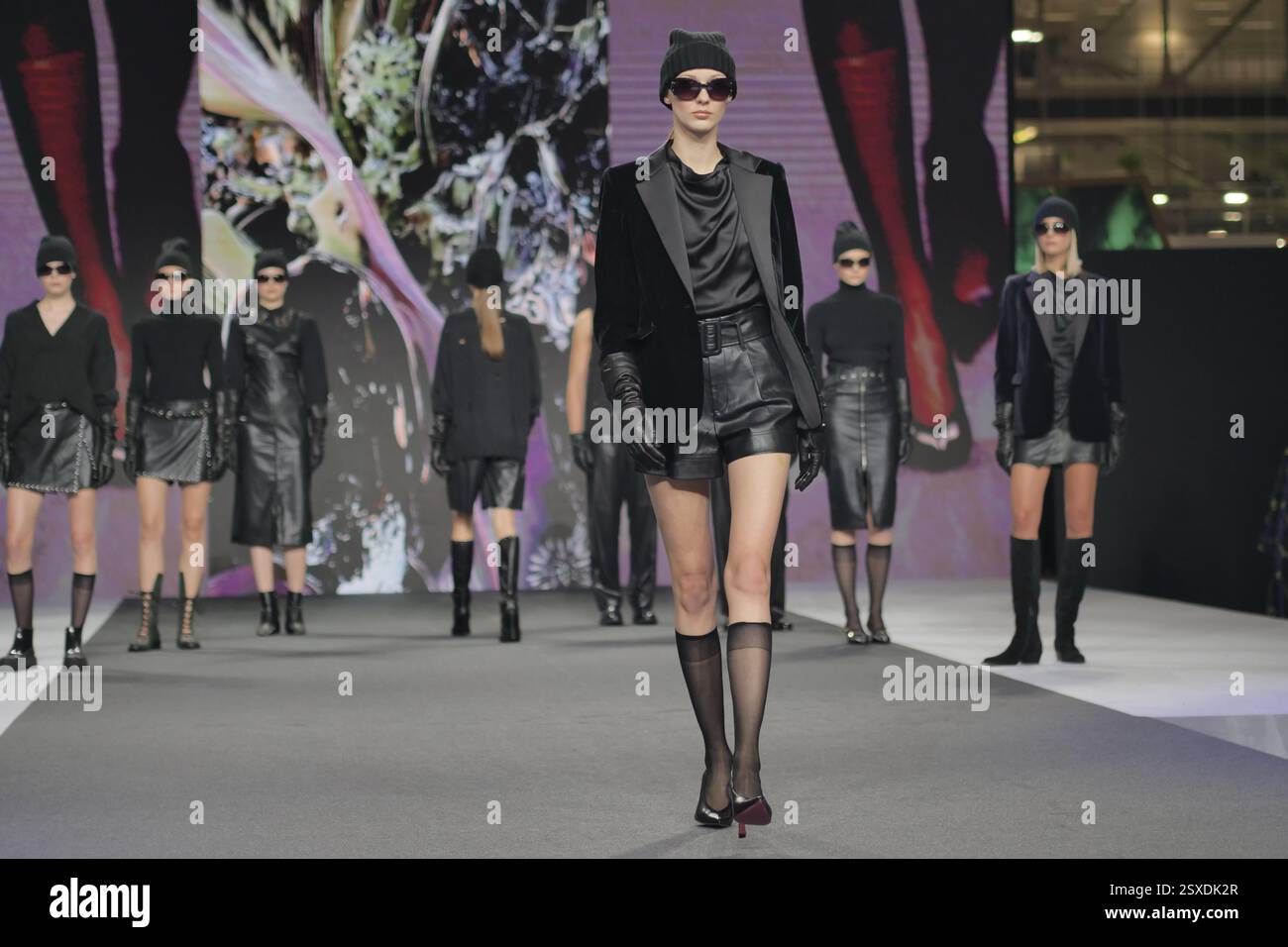Sfilata Micam: Evento sfilata di moda, con nuove tendenze stilistiche delle calzature abbinate a ginocchiere in nylon nero. Foto Stock