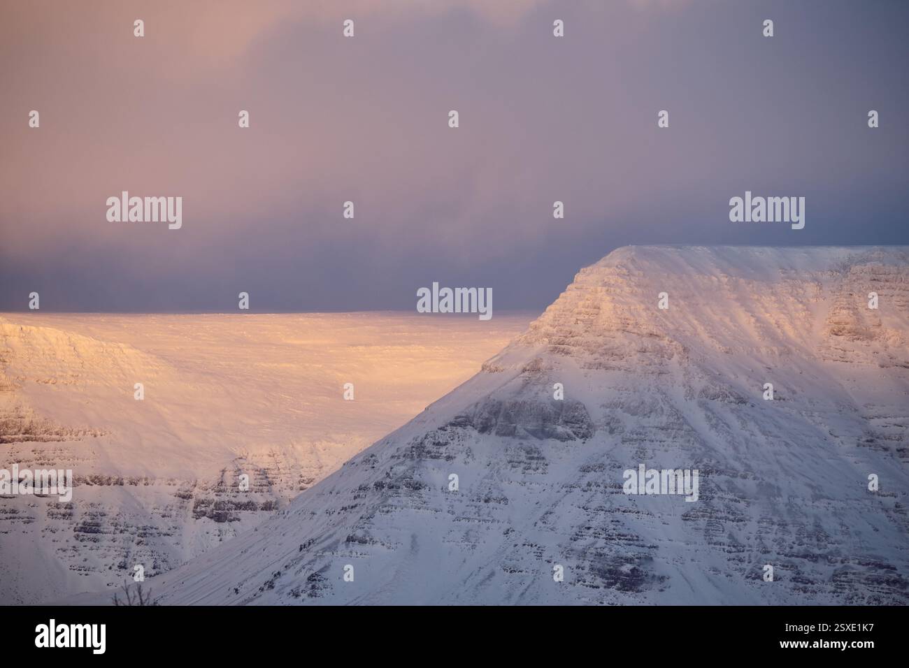 Vetta innevata che cattura la prima luce dell'alba in islanda Foto Stock