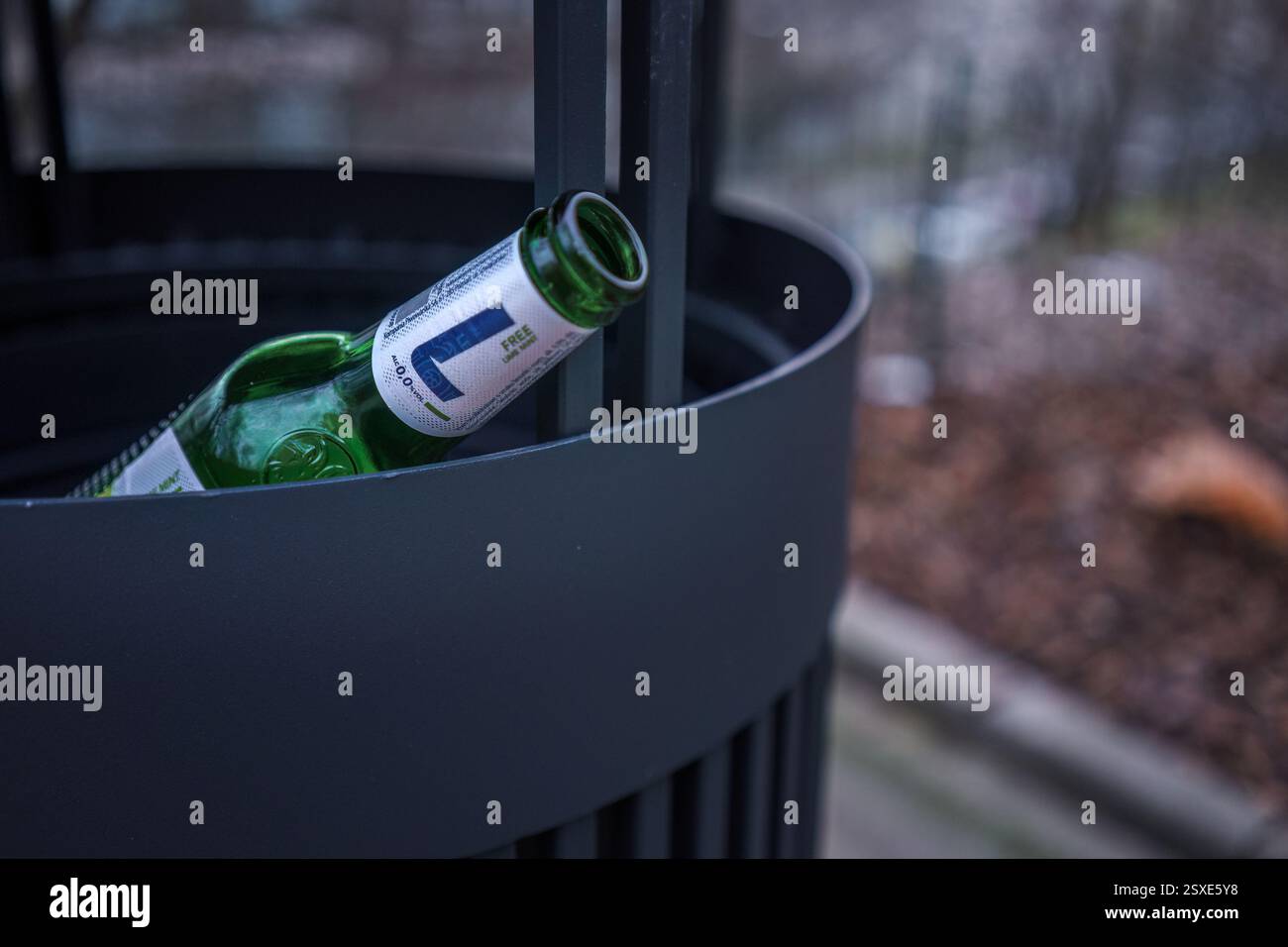 Varsavia, Polonia. 26 gennaio 2025 - bottiglia di birra analcolica vuota gettata in un cestino dei rifiuti Foto Stock