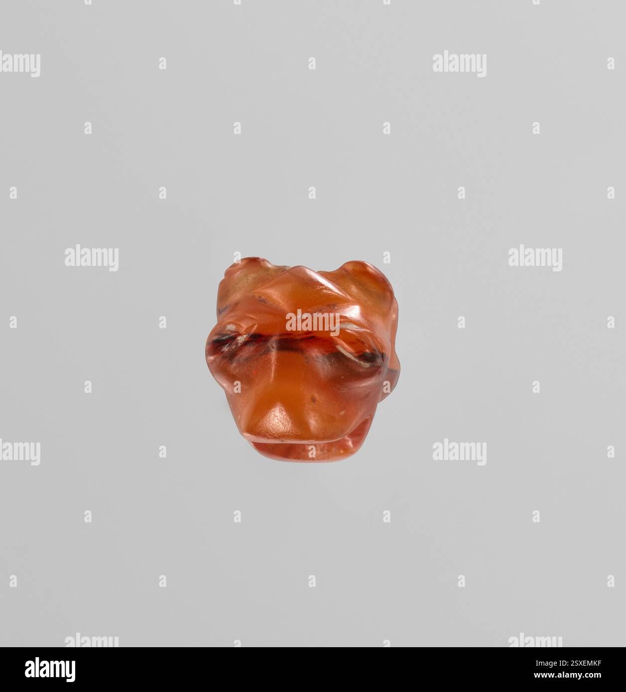 Questa perla carneliana minoica, risalente al 1650–1500 a.C. circa, presenta le teste di due leonesse scolpite dietro le quinte, un esempio impressionante di antica maestria artigianale nella scultura delle pietre preziose. Foto Stock