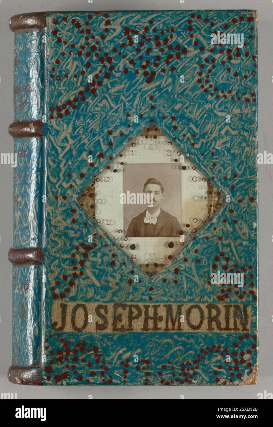 Una scatola matrimoniale del 1903 scolpita in morbido pino, simile a un libro rilegato in pelle. L'esterno e' decorato in modo intricato con marmo, blu e colori cordovani, con accenti di bronzo. La scatola include ritratti di una coppia all'interno, incisi con i loro nomi, e presenta un'iscrizione matrimoniale unica. Foto Stock