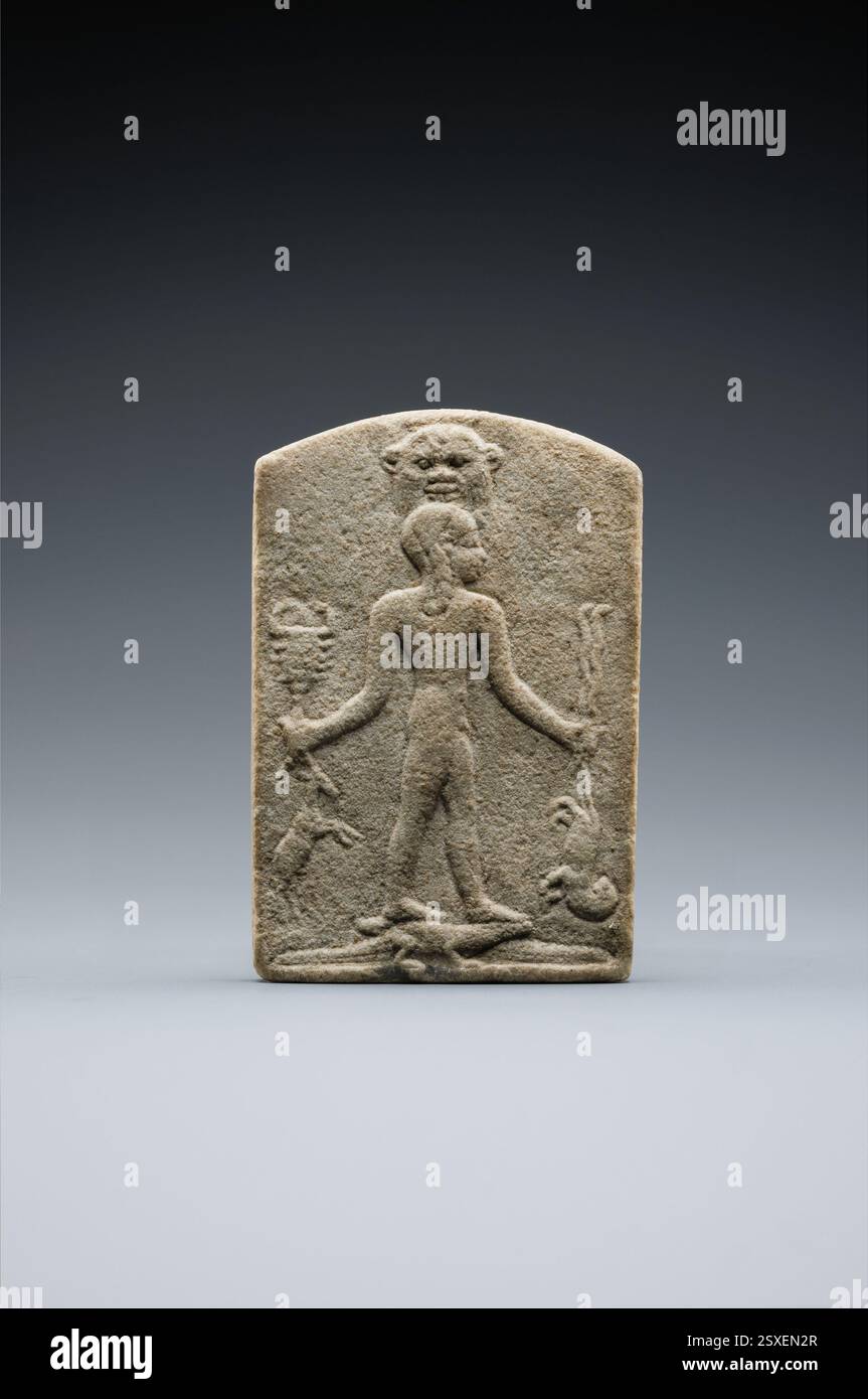 Una stele magica scolpita con la figura del dio bambino Horus che calpesta i coccodrilli e tiene in mano gli animali del deserto. Si credeva che la stele curasse i morsi di serpenti o scorpioni quando veniva versata acqua sopra di essa, mostrando le antiche credenze egiziane. Foto Stock