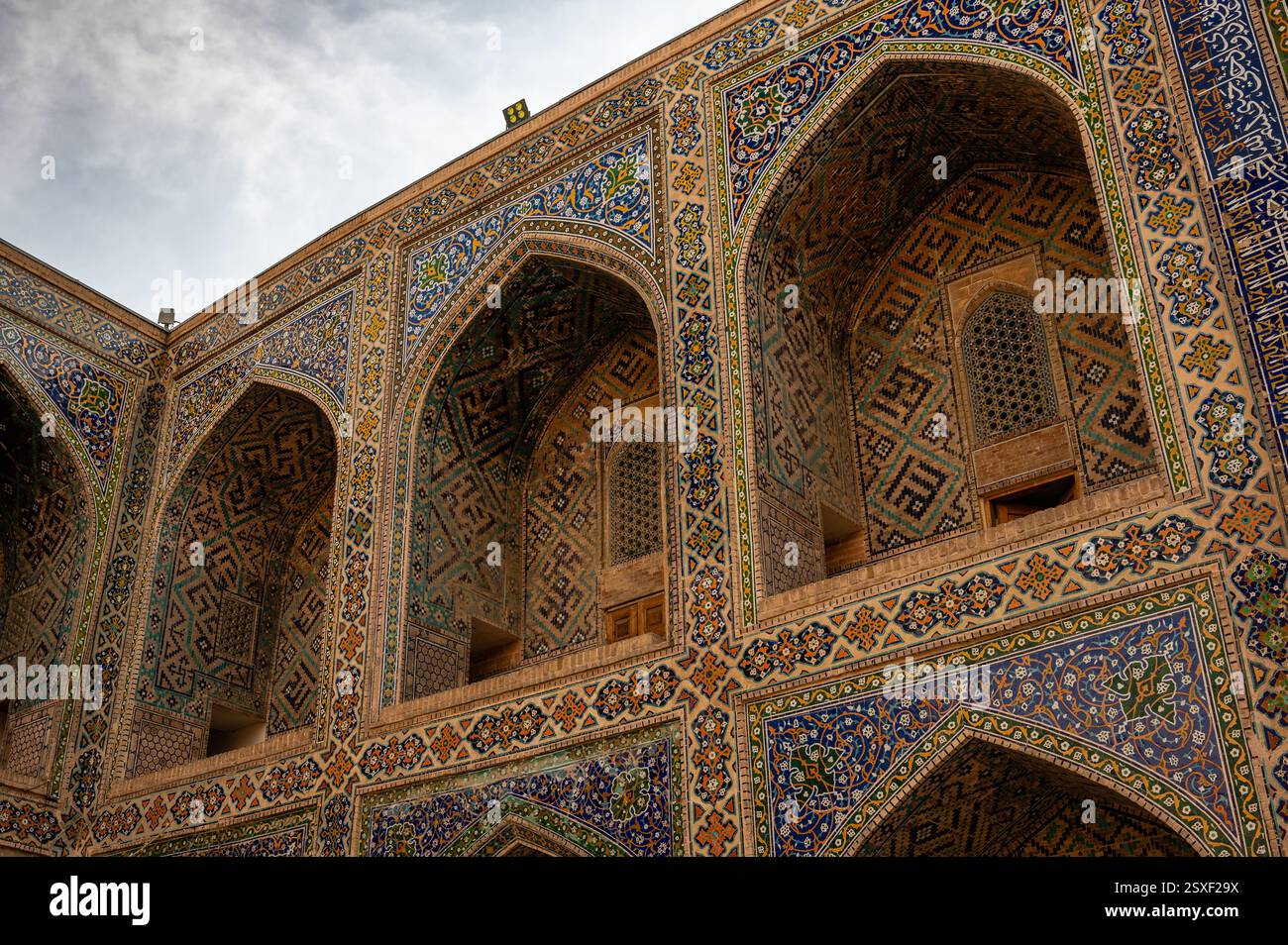 Dettagli degli archi piastrellati blu nel complesso Registan a Samarcanda, Uzbekistan, al tramonto Foto Stock
