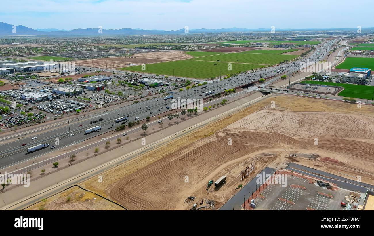 Il traffico autostradale si sposta rapidamente oltre Fields, proprietà commerciali in un ambiente suburbano a Phoenix, Arizona Foto Stock