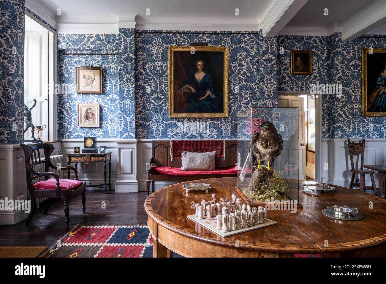 Scacchiera su un tavolo antico con carta da parati blu 'Pomegranate Grand' nella Bayfield Hall, una storica casa di campagna del XVIII secolo a Norfolk, Regno Unito. Foto Stock