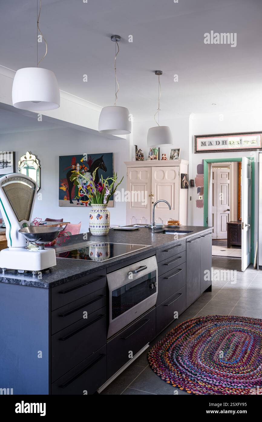 Bilance da cucina e tappeto con cucina in granito a Bayfield Hall, una casa di campagna ristrutturata del XVIII secolo a Norfolk, Regno Unito. Foto Stock