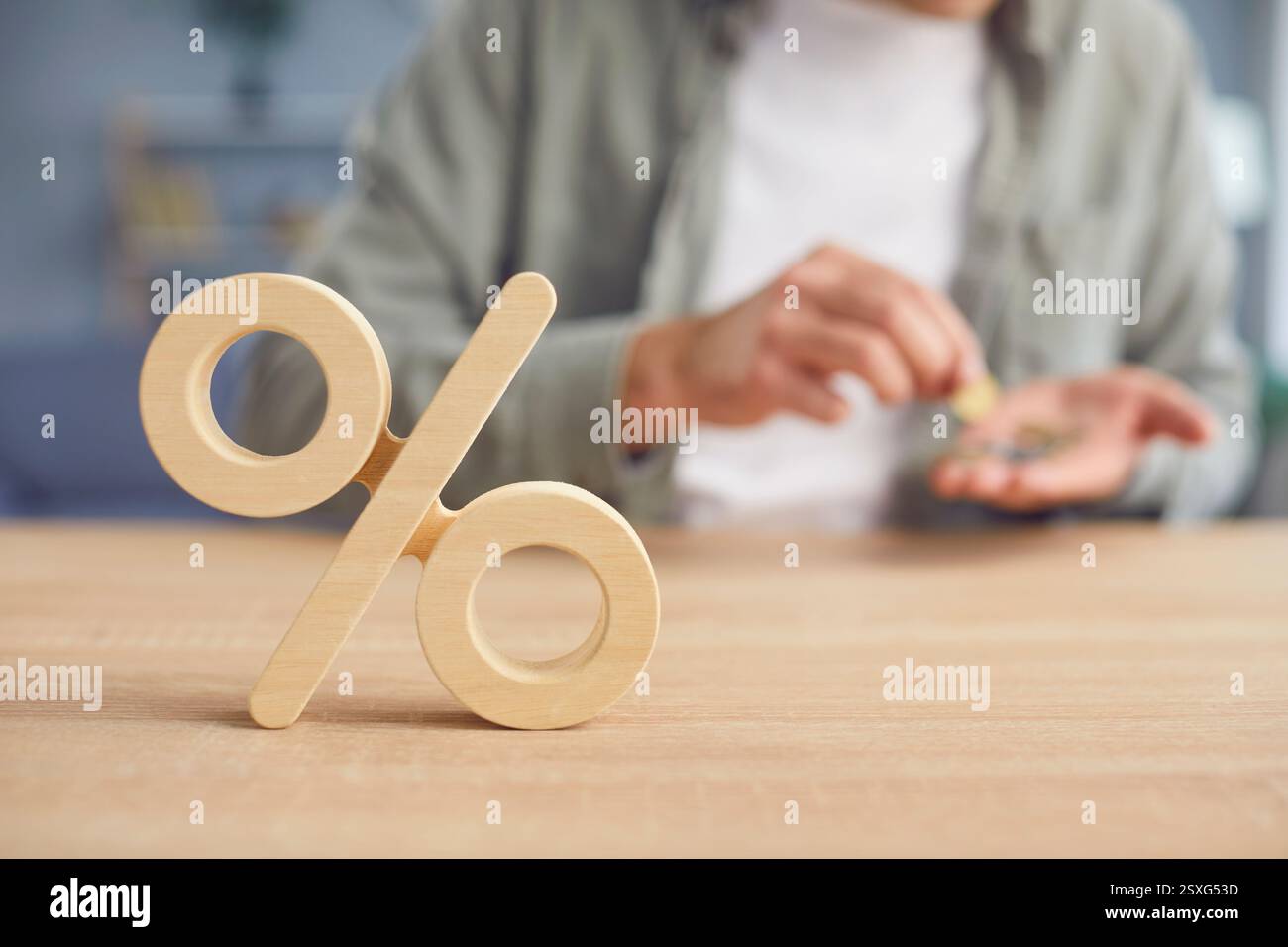 Primo piano con il simbolo di percentuale e l'uomo che conta i soldi nelle sue mani. Foto Stock