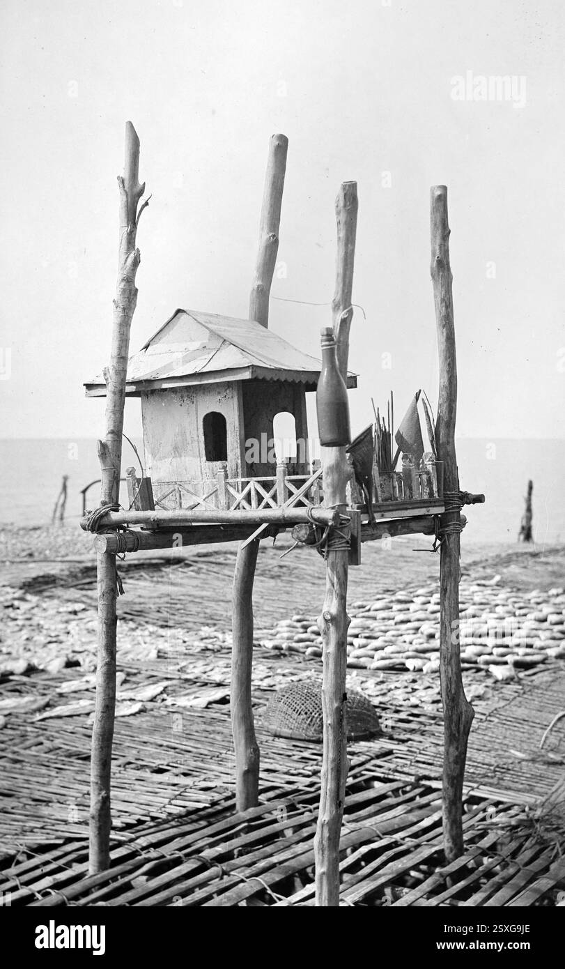 Santuario di legno eretto su pilastri di legno o Pilotis con casa in miniatura e offerte agli dei del Mare sulla riva del mare in Vietnam. Immagine vintage o storica in bianco e nero o monocromatica c1950 Foto Stock